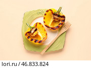 Тарелка с половинками вкусных жареных болгарских перцев на бежевом фоне. Стоковое фото, фотограф Pixel_shot / Фотобанк Лори