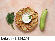 Тарелка вкусных кабачковых оладий с сметаной на светлом фоне. Стоковое фото, фотограф Pixel_shot / Фотобанк Лори
