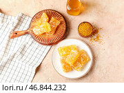 Деревянная доска и тарелка с сладкими медовыми сотами на бежевом фоне. Стоковое фото, фотограф Pixel_shot / Фотобанк Лори