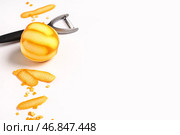 Композиция с свежим спелым апельсином и овощечисткой на белом фоне. Стоковое фото, фотограф Pixel_shot / Фотобанк Лори
