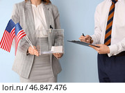 Женщина держит избирательный ящик и флаги США рядом с мужчиной с избирательным бюллетенем на подкладке на светлом фоне. Концепция выборов. Стоковое фото, фотограф Pixel_shot / Фотобанк Лори