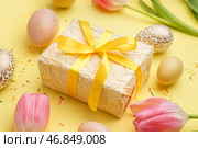 Подарок на Пасху, яйца и тюльпаны на желтом фоне. Стоковое фото, фотограф Pixel_shot / Фотобанк Лори