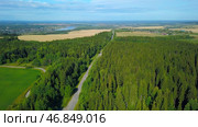 View from a helicopter. Clip. A bright summer green forest with a large forest and a road with cars nearby and in the distance you can see the road and the river. Стоковое фото, фотограф Данил Руденко / Фотобанк Лори