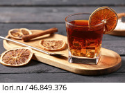 Доска с бокалом вкусного коктейля "Олд Фэшн" и апельсиновыми ломтиками на черном деревянном фоне. Стоковое фото, фотограф Pixel_shot / Фотобанк Лори
