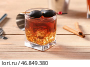 Бокал вкусного коктейля "Олд-фэшнед" с оливками на деревянном фоне. Стоковое фото, фотограф Pixel_shot / Фотобанк Лори