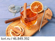 Доска с бокалом вкусного коктейля "Олд-фэшнед" и апельсиновыми дольками на фиолетовом деревянном фоне. Стоковое фото, фотограф Pixel_shot / Фотобанк Лори