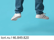 Ноги молодого человека в белых стильных кроссовках, прыгающего на голубом фоне. Стоковое фото, фотограф Pixel_shot / Фотобанк Лори