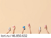 Руки, держащие ведра с попкорном и напитками на бежевом фоне. Стоковое фото, фотограф Pixel_shot / Фотобанк Лори