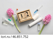 Календарь с цветами, шприцами и ампулами ко Дню международной медсестры на белом фоне. Стоковое фото, фотограф Pixel_shot / Фотобанк Лори