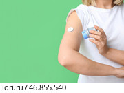 Женщина с глюкозным датчиком для измерения уровня сахара в крови и аппликатором на зеленом фоне. Концепция диабета. Стоковое фото, фотограф Pixel_shot / Фотобанк Лори