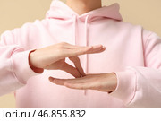Молодой глухонемой мужчина использует жестовый язык на бежевом фоне, крупным планом. Стоковое фото, фотограф Pixel_shot / Фотобанк Лори