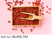 Деревянная коробка и черпак с красными сушеными ягодами годжи на розовом фоне. Стоковое фото, фотограф Pixel_shot / Фотобанк Лори