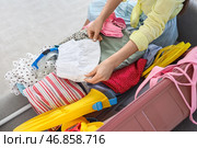Женский турист упаковывает летнюю одежду в чемодане дома, крупным планом. Стоковое фото, фотограф Pixel_shot / Фотобанк Лори