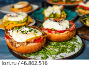 Тарелки с вкусными яйцами Бенедикт на столе, крупным планом. Стоковое фото, фотограф Pixel_shot / Фотобанк Лори