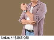 Зрелый мужчина закатывает рукав на зеленом фоне, крупным планом. Стоковое фото, фотограф Pixel_shot / Фотобанк Лори
