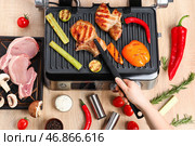 Женщина готовит вкусные стейки и овощи на современном электрическом гриле за столом. Стоковое фото, фотограф Pixel_shot / Фотобанк Лори