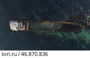 Aerial top view for wrecked ship along the rocky coast in blue water. Стоковое фото, фотограф David Kashakhi / Фотобанк Лори
