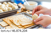 Passover preparation with matzah crackers and handmade matzo balls. Стоковое AI-изображение, AI-художник Анастасия Золотницкая / Фотобанк Лори