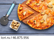 Доска вкусной пиццы из морепродуктов на синем деревянном фоне, крупным планом. Стоковое фото, фотограф Pixel_shot / Фотобанк Лори