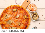 Доска с вкусной пиццей из морепродуктов и ингредиентами на светлом деревянном фоне. Стоковое фото, фотограф Pixel_shot / Фотобанк Лори