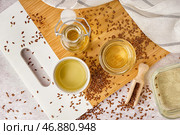Бутылка, стаканы с льняным маслом и семенами на светлом фоне. Стоковое фото, фотограф Pixel_shot / Фотобанк Лори