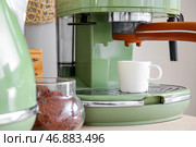 Современная кофемашина, чашки и банка с печеньем на столе возле белой стены, крупным планом. Стоковое фото, фотограф Pixel_shot / Фотобанк Лори