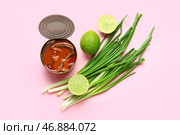 Открытая консервная банка с рыбой в томатном соусе, лаймом и зеленым луком на розовом фоне. Стоковое фото, фотограф Pixel_shot / Фотобанк Лори