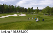 Golfers hitting golf shot with club on course while on summer vacation, aerial. Стоковое фото, фотограф David Kashakhi / Фотобанк Лори