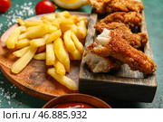 Тарелка вкусной жареной трески с картофелем фри на зеленом фоне. Стоковое фото, фотограф Pixel_shot / Фотобанк Лори