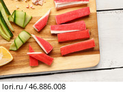 Доска с вкусными крабовыми палочками на светлом деревянном фоне. Стоковое фото, фотограф Pixel_shot / Фотобанк Лори