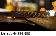 Acoustic guitar bridge and strings close up. Стоковое фото, фотограф David Kashakhi / Фотобанк Лори