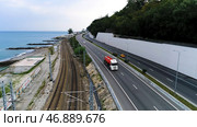 Aerial view of a truck driving on the road along the sea coast and rails, transportation concept. Стоковое фото, фотограф David Kashakhi / Фотобанк Лори