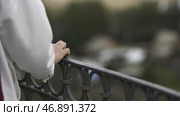 Close up of tender hand of a female touching iron handrail of the balcony on blurred background. Стоковое фото, фотограф David Kashakhi / Фотобанк Лори