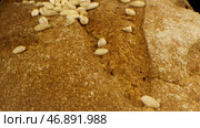 Close up of rustic rye loaf of bread with crispy crust and falling seeds, concept of healthy nutrition. Стоковое фото, фотограф David Kashakhi / Фотобанк Лори