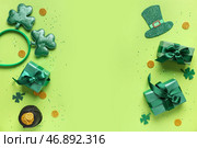 Подарочные коробки с ободком, горшком золотых монет и декорациями для празднования Дня святого Патрика на зеленом фоне. Стоковое фото, фотограф Pixel_shot / Фотобанк Лори
