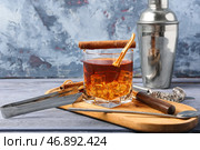 Доска с бокалом вкусного коктейля "Олд-фэшнед" и кусочком апельсина на синем деревянном столе. Стоковое фото, фотограф Pixel_shot / Фотобанк Лори
