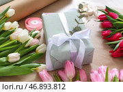 Композиция с подарочной коробкой, упаковочными материалами и красивыми тюльпанами к Международному женскому дню на деревянном фоне. Стоковое фото, фотограф Pixel_shot / Фотобанк Лори