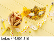 Карнавальная маска и печенье Hamantaschen на праздник Пурим с воздуходувками на цветном деревянном фоне. Стоковое фото, фотограф Pixel_shot / Фотобанк Лори