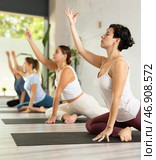 Group of active women practicing Dove pose Vajra Kapotasana yoga positions during training indoors. Focus on young Latin female. Стоковое фото, фотограф Яков Филимонов / Фотобанк Лори