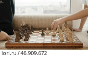 A chessboard with white and black pieces and two people playing. Стоковая иллюстрация, иллюстратор David Kashakhi / Фотобанк Лори
