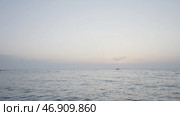 The undulating sea in the landscape against the background of a slightly misty sky, behind which ships sail in the distance. Стоковое фото, фотограф David Kashakhi / Фотобанк Лори