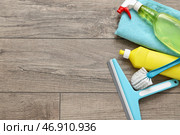 Бутылки с моющим средством, тряпка, скребок и щетка на фоне из ламината. Стоковое фото, фотограф Pixel_shot / Фотобанк Лори