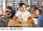 Boy gives the read books to the librarian in school library. Стоковое фото, фотограф Яков Филимонов / Фотобанк Лори