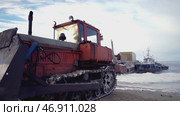 In the snow, a bulldozer spins its wheels when it pulls something heavy. Стоковое фото, фотограф David Kashakhi / Фотобанк Лори