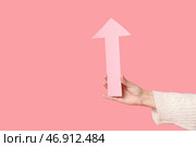 Женская рука с бумажной стрелкой, указывающей на что-то на розовом фоне. Стоковое фото, фотограф Pixel_shot / Фотобанк Лори