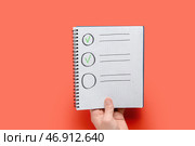 Мужчина держит пустой чек-лист на красном фоне. Концепция опроса. Стоковое фото, фотограф Pixel_shot / Фотобанк Лори