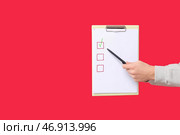 Мужчина держит пустой чек-лист на красном фоне. Концепция опроса. Стоковое фото, фотограф Pixel_shot / Фотобанк Лори