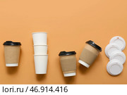 Одноразовые кофейные стаканчики на оранжевом фоне. Стоковое фото, фотограф Pixel_shot / Фотобанк Лори
