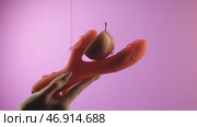 Pink background.Creative.Vibrator, held in hand, into which they put a bright red apple and poured with a slimy white cream. Стоковая иллюстрация, иллюстратор David Kashakhi / Фотобанк Лори