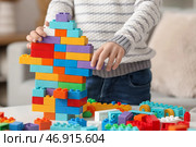 Милый маленький мальчик играет с цветными игрушечными кирпичиками на столе дома, крупный план. Стоковое фото, фотограф Pixel_shot / Фотобанк Лори